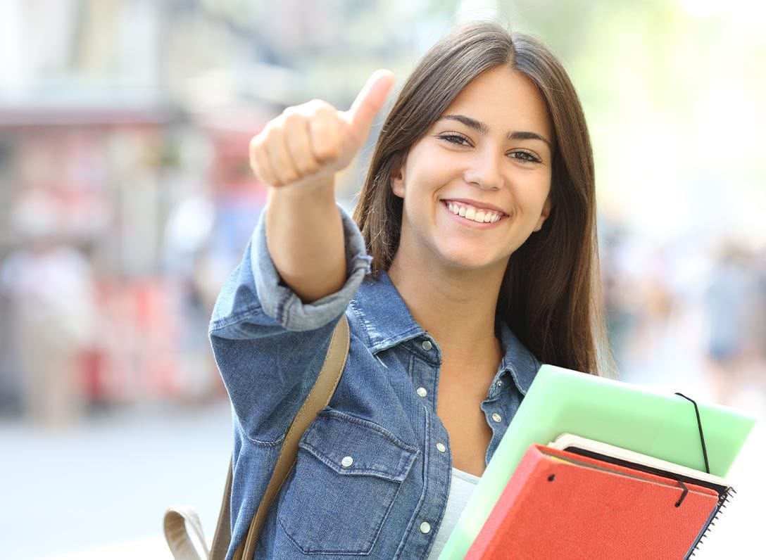 Nounou étudiante sortant de la fac faisant un pouce levé à la caméra