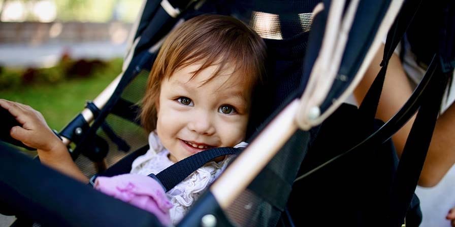 Petite fille souriante dans une poussette