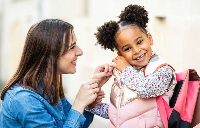 Nounou allant chercher une petite fille métisse à la sortie de l'école