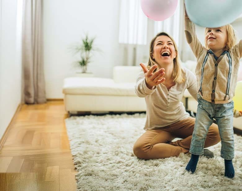Nounou et enfant qui jouent avec des ballons dans le salon
